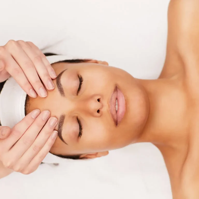 Above view portrait of beautiful mixed-race woman enjoying face massage in luxury spa, copy space